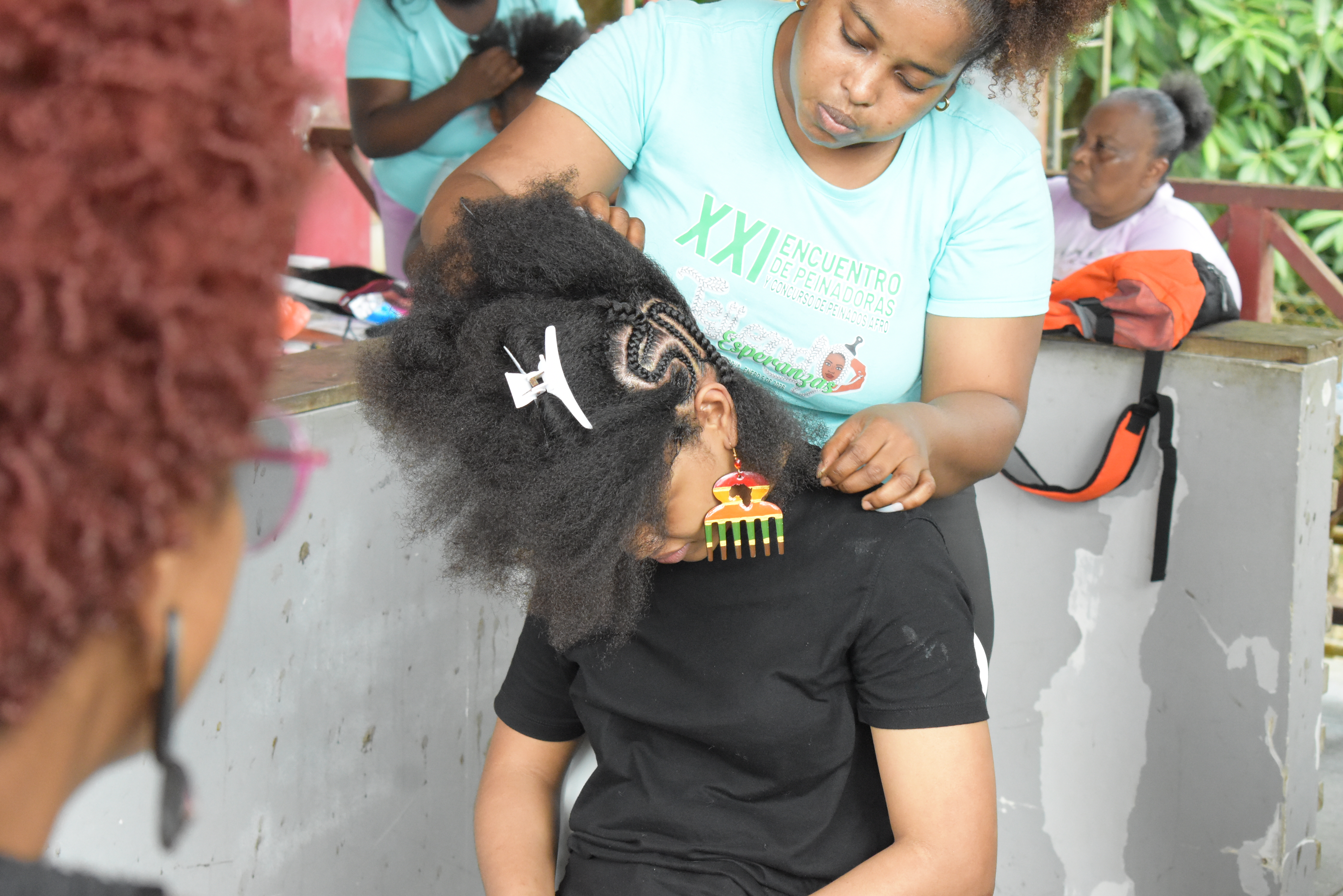 A traditional hairdresser braids her model's hair during the Tejiendo Esperanzas (Weaving Hopes) competition