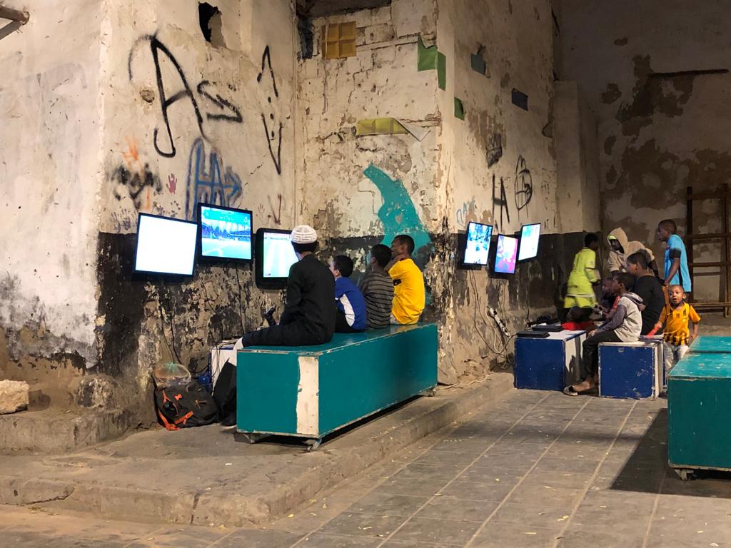 Bruno Schmidt-Feuerheerd - “Young residents of Jeddah’s old town with consoles outdoors" Bruno Schmidt-Feuerheerd - “Young residents of Jeddah’s old town with consoles outdoors"