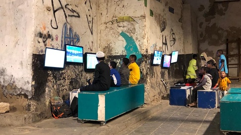 Young residents of Jeddah’s old town with consoles outdoors.