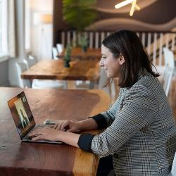 Photo by LinkedIn Sales Solutions on Unsplash: A woman sitting at a table with a laptop, focused on her work.